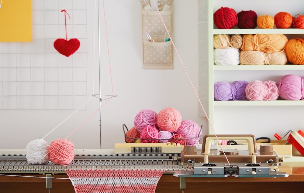 Knitting machine with pink wool in a craft room
